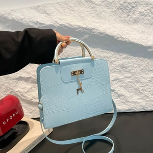 Sac à main bleu clair en similicuir crocodile avec poignée dorée et pendentif cerf