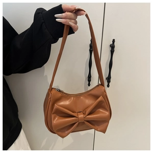 Détail du sac bandoulière en similicuir marron avec grand nœud décoratif et fermeture éclair
