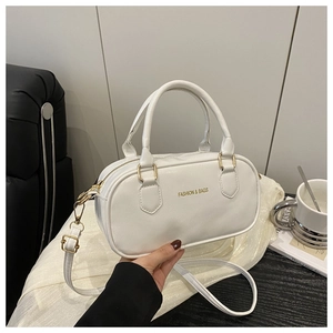 Close-up of white bowling bag with gold hardware and removable shoulder strap