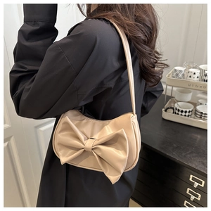 Détail d'un sac sous le bras blanc crème avec un grand nœud décoratif en cuir 3D