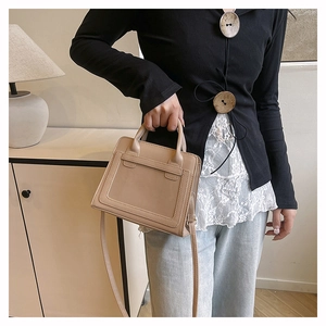 Detail der beigen Kunstledertasche mit Ziernähten und langem Schultergurt