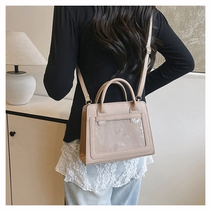 Lifestyle-Ansicht der beigen Ita-Tasche mit großem PVC-Fenster und verstellbarem Schultergurt