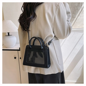 Rear view of a black PU leather handbag with a transparent window and adjustable strap