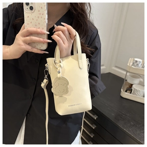 Détail du mini sac seau blanc cassé avec texte mode et breloque chien amovible