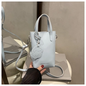 Mini borsa a secchiello in pelle celeste con ciondolo a cane e tracolla regolabile