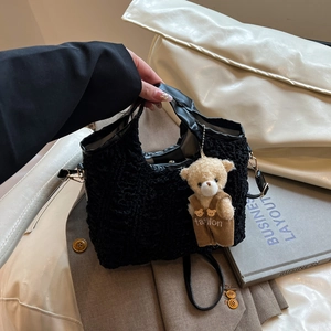 Chic black pleated bucket bag with plush bear charm and versatile crossbody strap