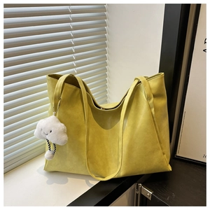 Détail du grand sac cabas jaune texturé avec un joli pendentif nuage en peluche blanche