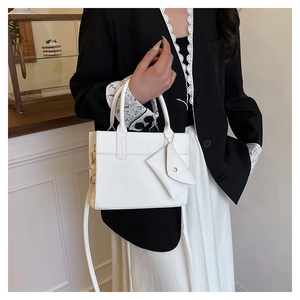 Detailed view of white faux leather crossbody bag with detachable mini triangle pouch