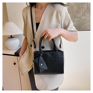 Detail of black rectangular tote bag with mini triangle pouch and fashion lettering