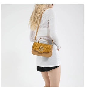 Detail of camel brown crossbody bag featuring woven texture and gold M logo on a model