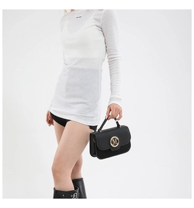 Detail of black lychee grain mini square bag with golden M logo and reinforced handle