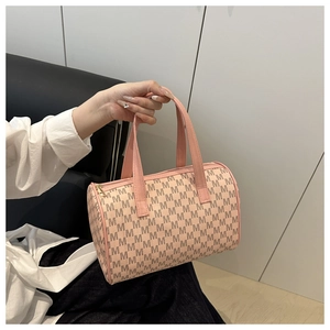 Détail du sac Boston rose avec imprimé monogramme, poignées en cuir et zip doré