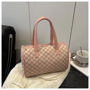 Détail d'un sac Boston rétro avec imprimés lettres M posé sur une surface blanche