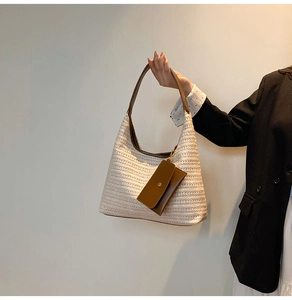 Close-up of straw woven tote with leather straps and a matching magnetic coin purse