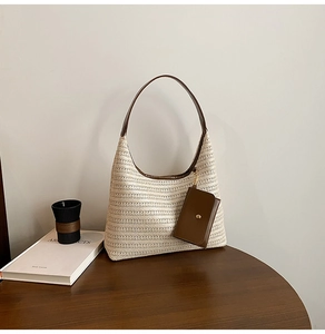 Detailed straw weave texture of beige tote bag with leather strap and mini pouch