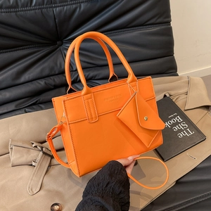Chic orange rectangular crossbody tote bag with dual handles and mini envelope charm