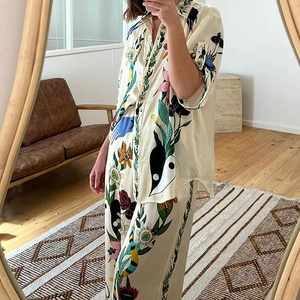 Détail d'un ensemble en satin crème imprimé avec chemise à col cubain et pantalon large