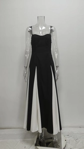 Detail of elegant high-waisted black and white maxi dress with pleated geometric hemline