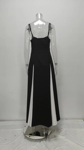 Back view of a long black and white contrast dress with thin straps and a wide A-line hem