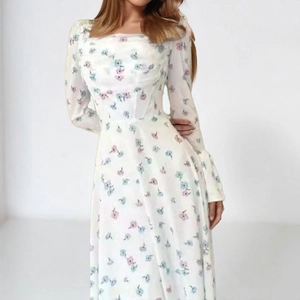 Close-up of floral print and waist pleats on elegant chiffon dress with square neck