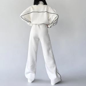 Rear view of white two-piece tracksuit with contrast black piping and wide-leg pants