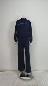 Detail of dark blue sporty track suit with white piping on zipper jacket and wide-leg pants
