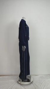 Detail of dark blue two-piece tracksuit showing white contrast piping on sleeves and trousers