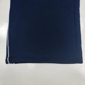 Detail showing navy knit fabric texture with white side stripe and double stitching