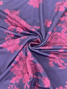 Detailed macro view of purple floral fabric with pink flower patterns and silky texture