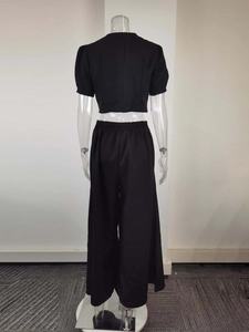 Vue arrière de l'ensemble noir deux pièces avec haut court et pantalon large taille haute