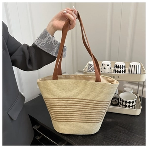 Detail of hand-woven straw tote with chic striped pattern and durable handles