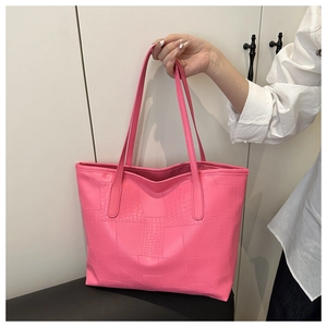 Detail of pink tote bag with crocodile texture and geometric splicing design