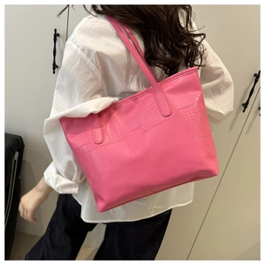 Detail of large pink tote bag with crocodile texture and refined stitching detail