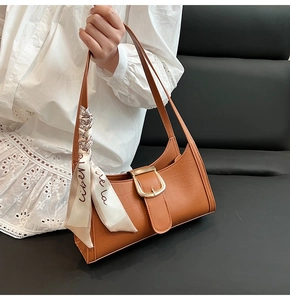 Détail du sac bandoulière marron motif crocodile avec foulard et boucle dorée