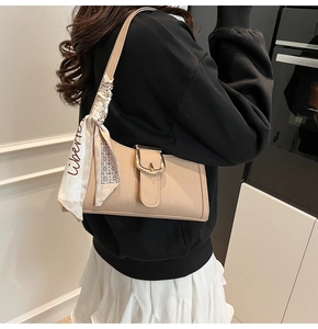 Détail du sac baguette abricot à texture crocodile avec son foulard en soie blanche