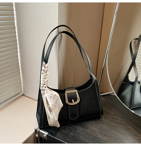 Détail du sac hobo noir à effet croco avec boucle dorée et poignée décorée d'un foulard