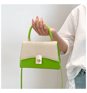 Détail du sac bicolore avec cuir vert, tissage beige et fermoir métallique doré élégant