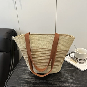 Handmade woven straw tote bag with brown stripes and dual fabric handles for beach vacations