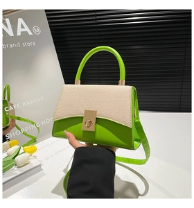 Détail du petit sac bandoulière en cuir vert et tissu tissé avec fermoir doré en métal