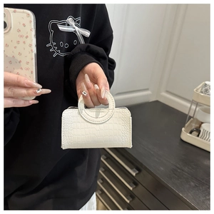 Vue détaillée du mini sac à main blanc avec texture crocodile et poignée élégante