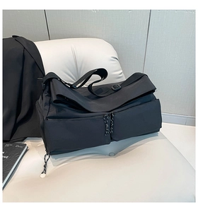 Detail of black waterproof nylon fitness bag with front zipper pockets and wide strap