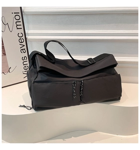 Detail of black tactical nylon crossbody bag with dual utility pockets and patterned zip pullers
