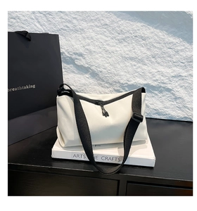 Nahaufnahme der minimalistischen weißen Kuriertasche mit schwarzem breitem Schultergurt