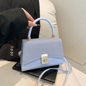 Sac bandoulière bleu clair structuré avec rabat tissé et fermoir rotatif doré