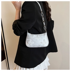 Detail of embroidered butterfly tote bag with decorative oval link chain strap