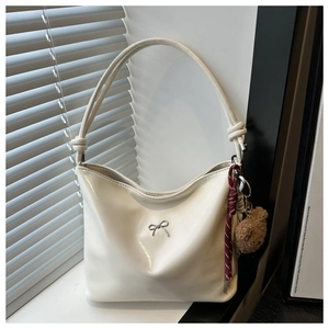 Chic cream PU tote bag featuring a silver bow accent and a cute plush bear charm detail