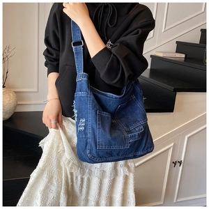 Detail of vintage denim tote bag with distressed texture and adjustable shoulder strap