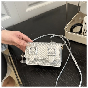 Close-up of silver-gray textured mini crossbody bag with double buckle straps