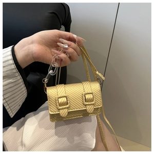 Detail of mini metallic yellow crossbody bag featuring woven texture and acrylic chain handle