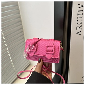 Macro shot of rose red woven texture and acrylic chain on stylish crossbody bag